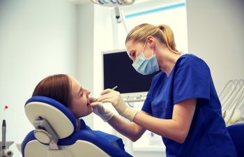 Dental Assistant Cleabing a Patient's Teeth